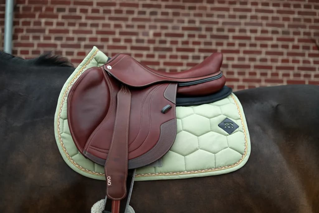 Tapis de selle vert tilleul sous une selle marron