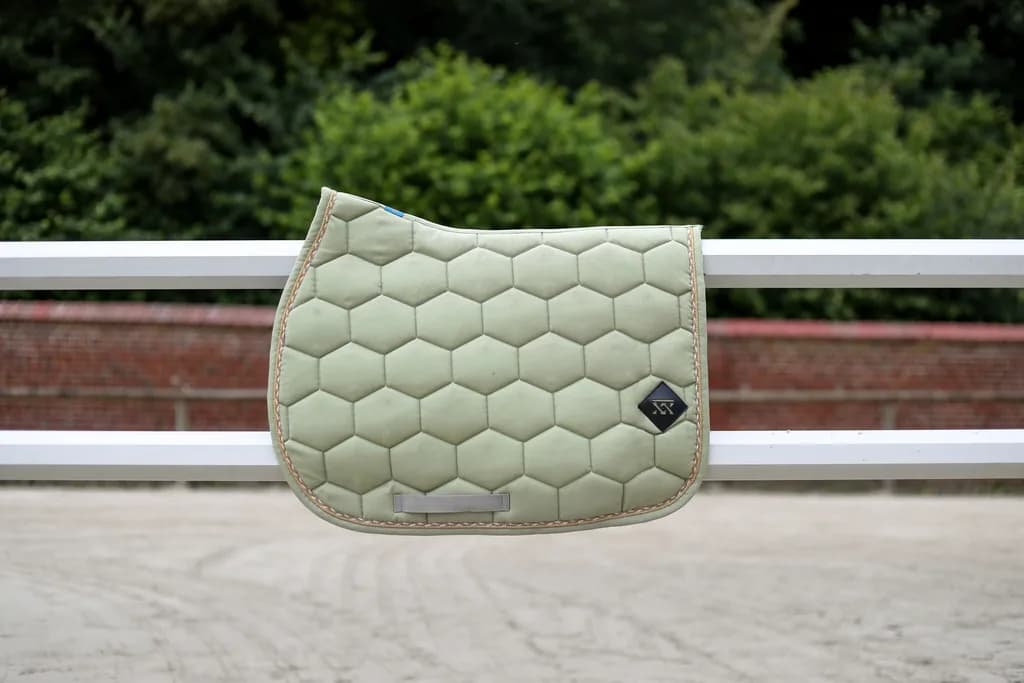 Tapis de selle vert tilleul sur cheval noir au paddock