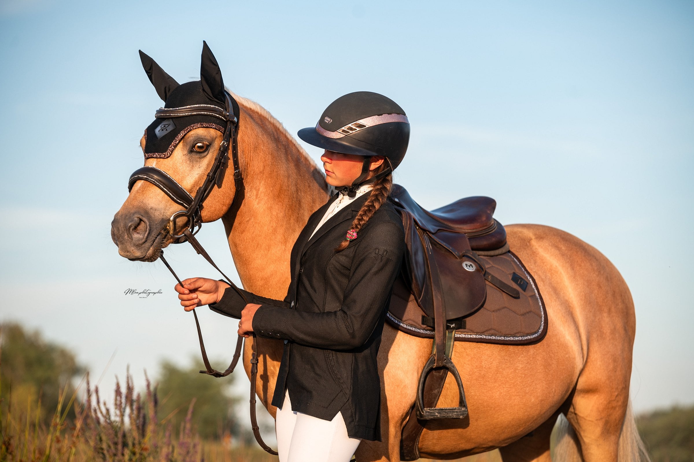 Cavalière près d'un cheval alezan, tapis de selle marron glacé et bonnet assorti